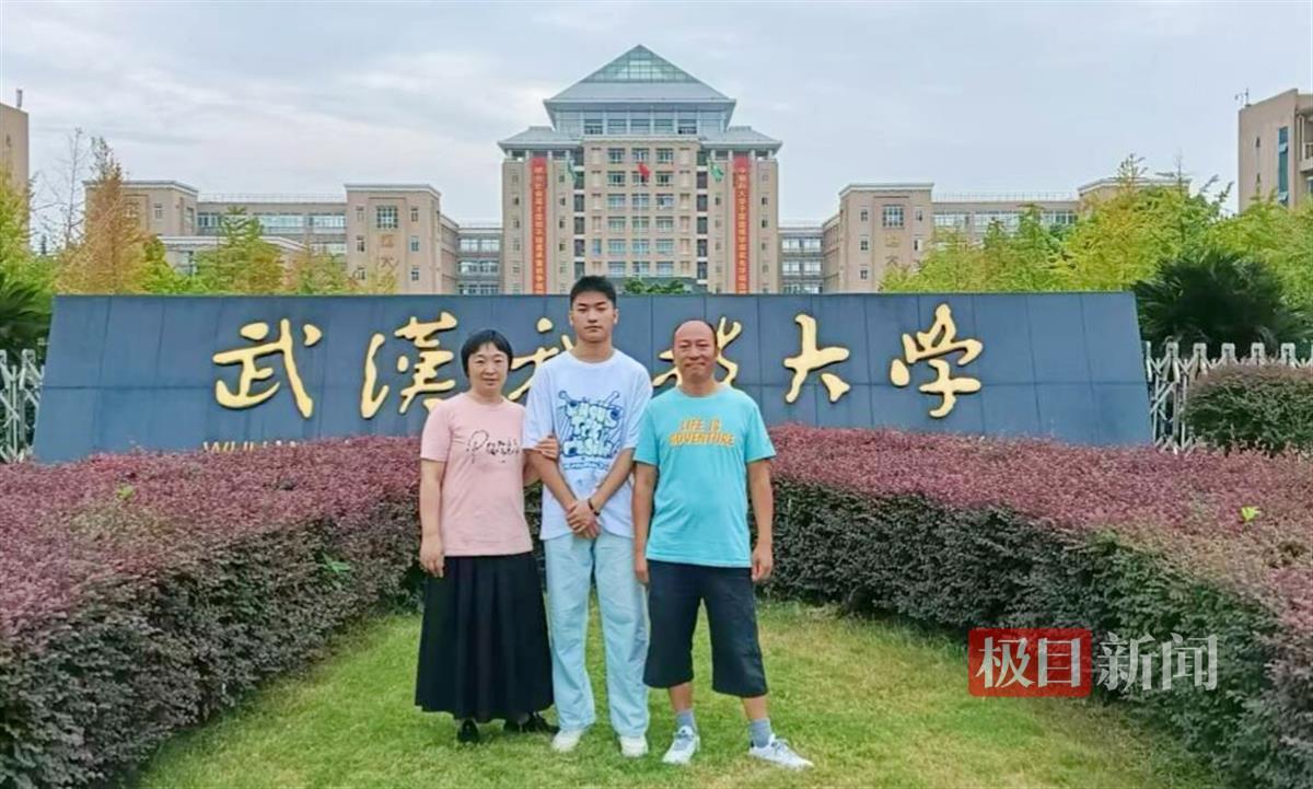 一家三口在校门口合影。学校供图.jpg
